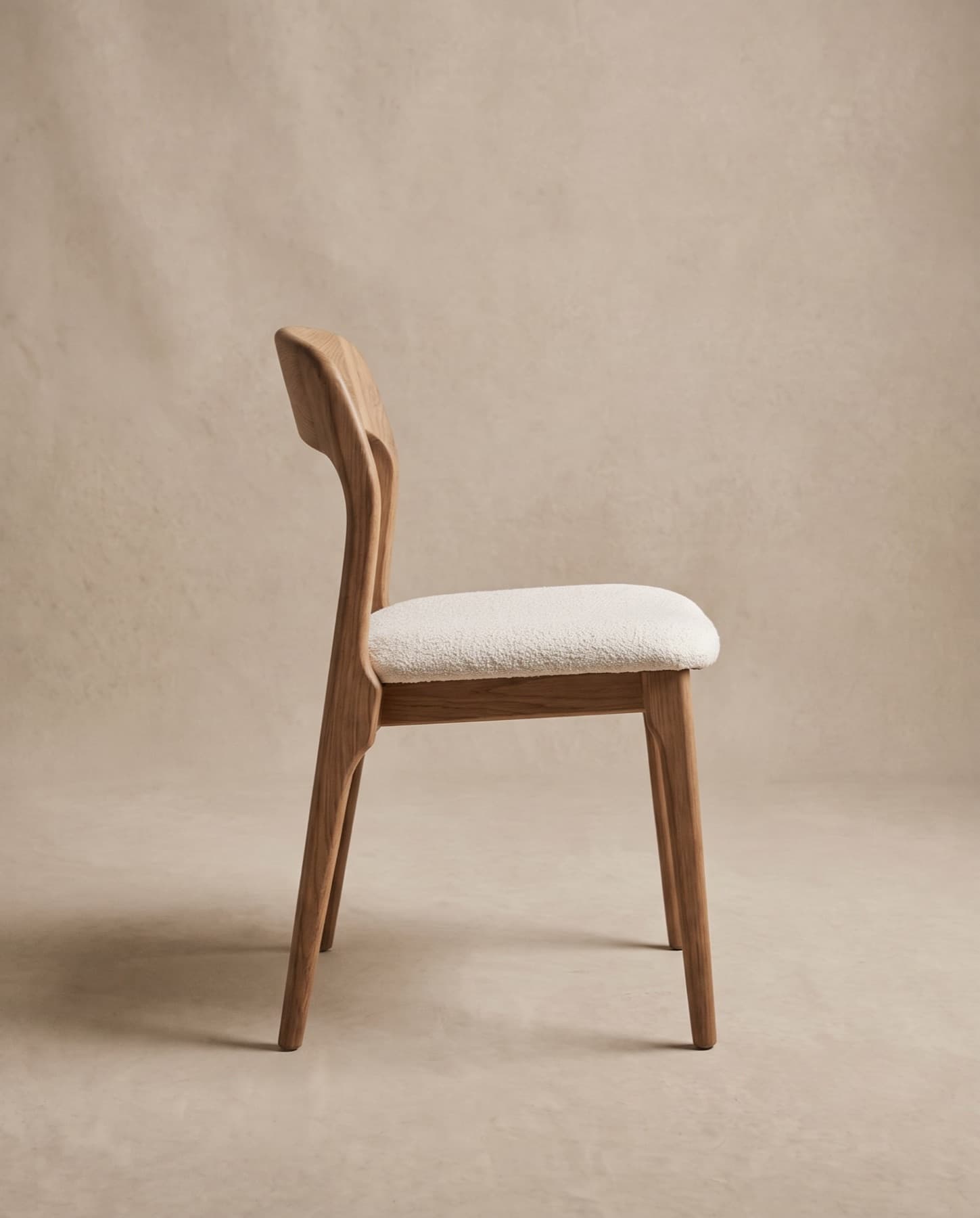 Arden dining chair seen in side profile, showing the angled back and slim oak legs