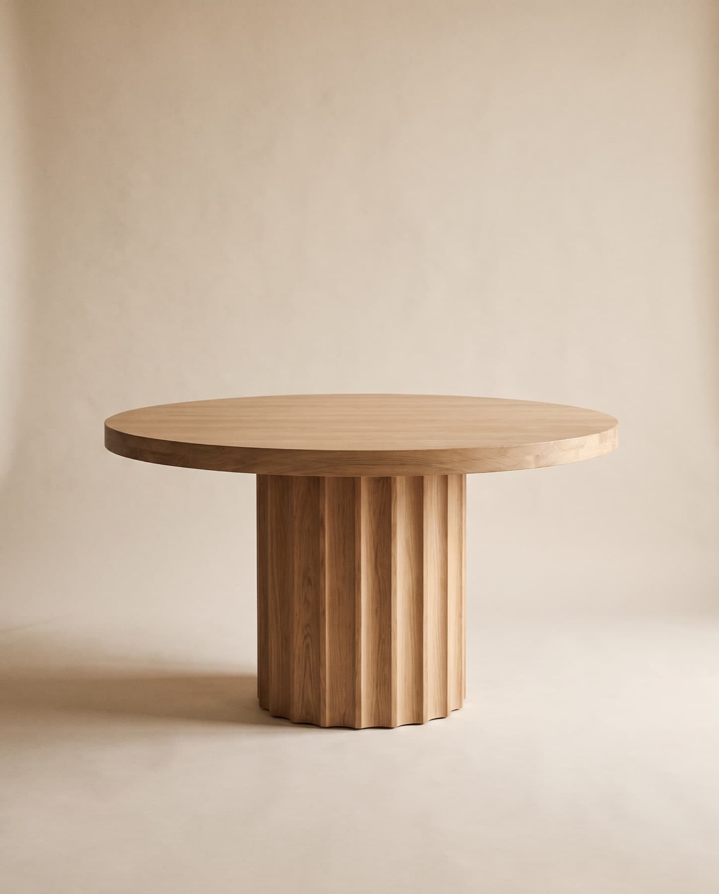 Loma round dining table in oak on a fluted pedestal base
