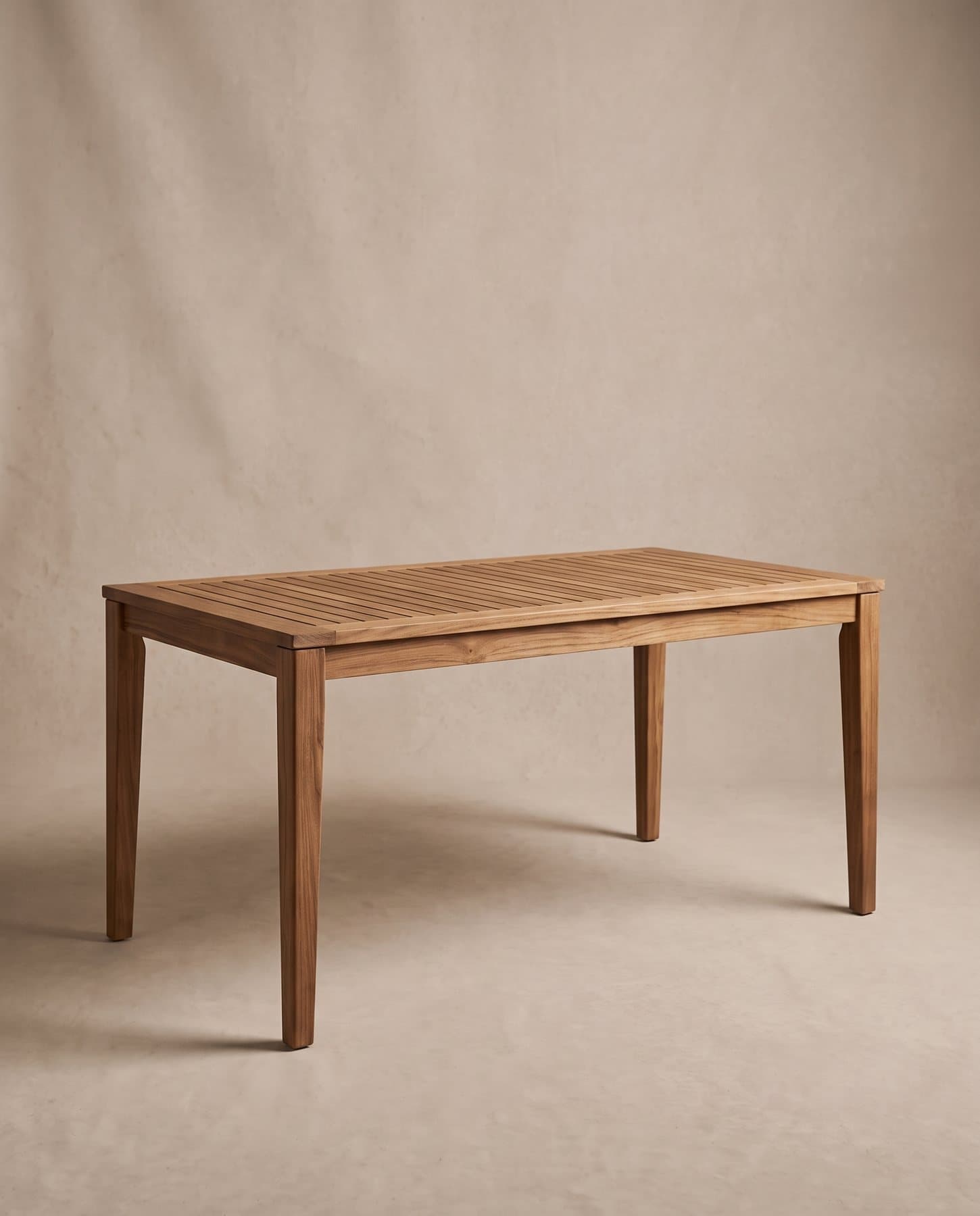 Marea outdoor dining table in solid teak with a slatted top and tapered square legs