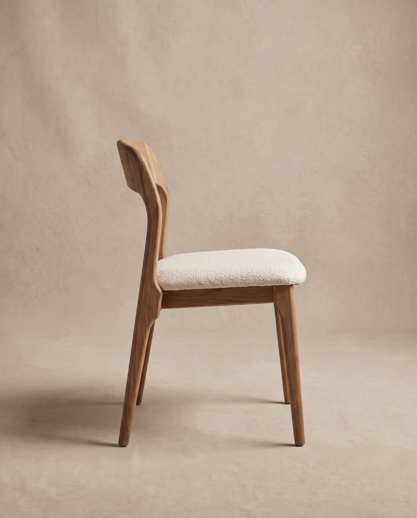 Arden dining chair seen in side profile, showing the angled back and slim oak legs