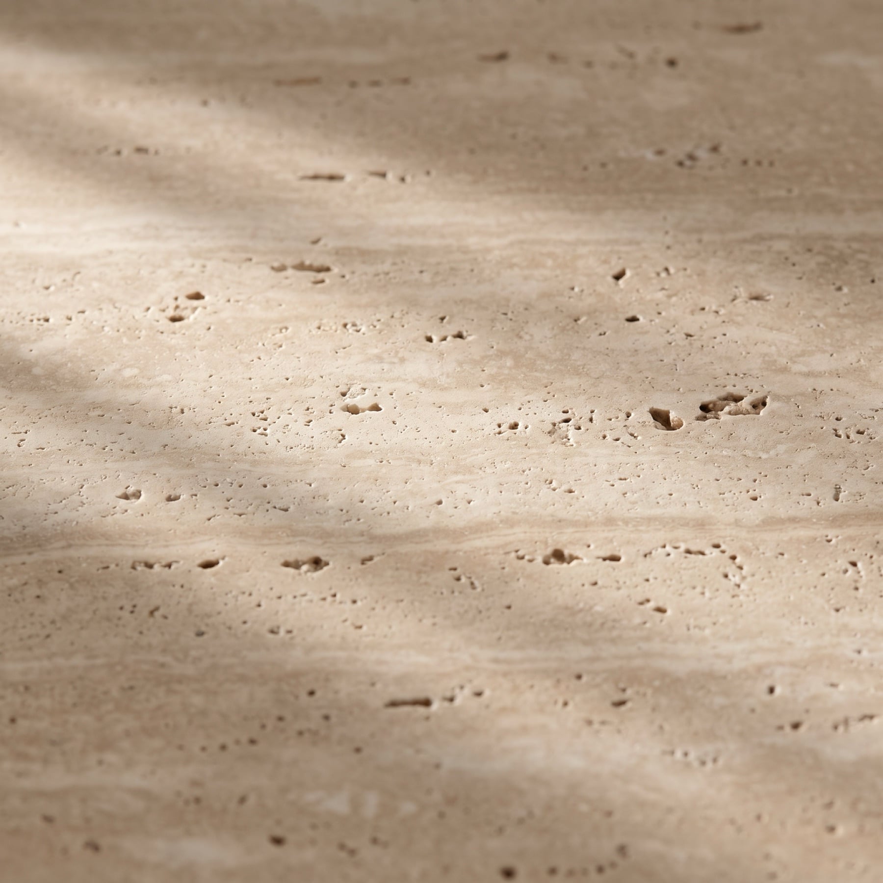 Close-up of honed Roman travertine with soft banding and small open pores