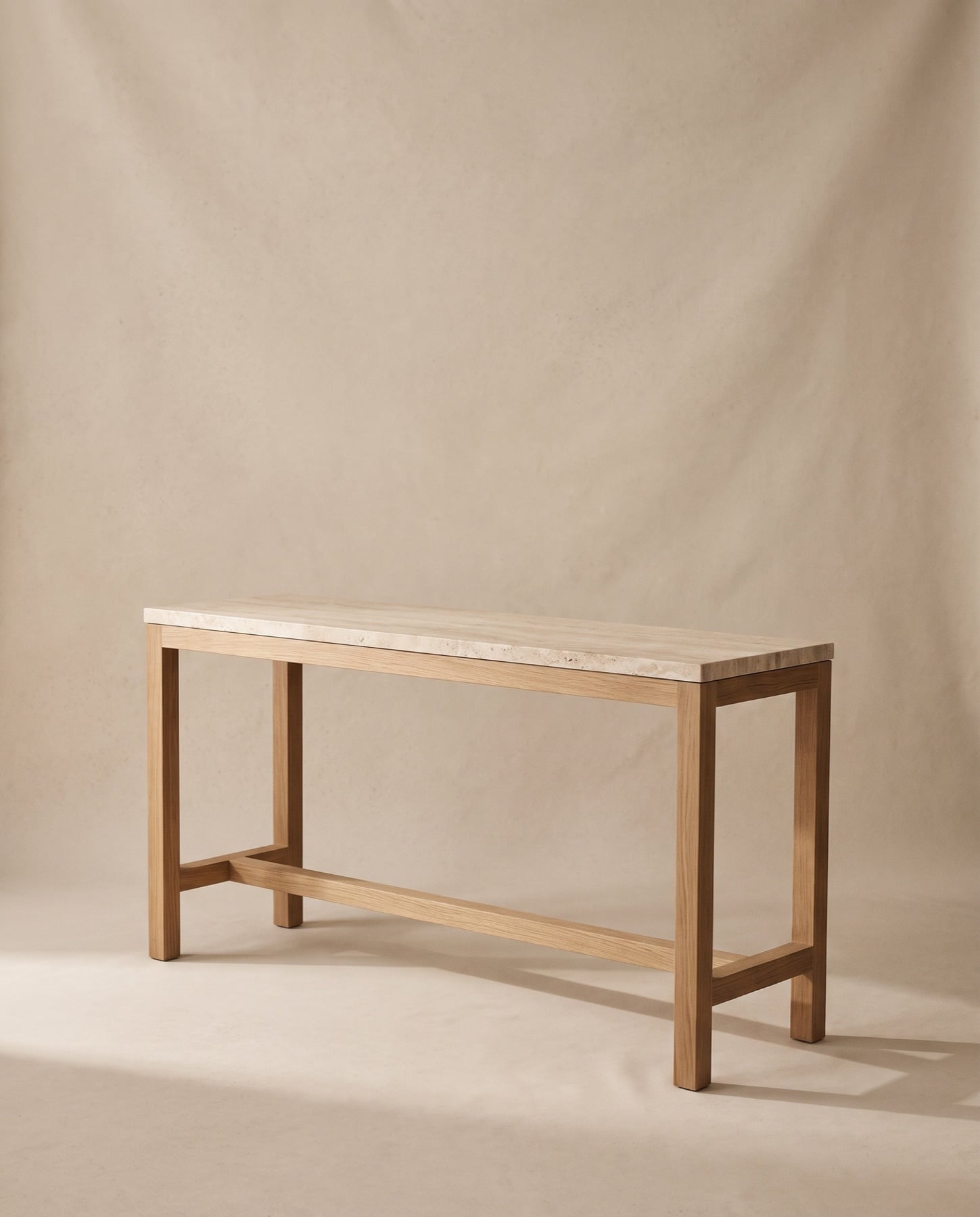Atlas console with a travertine top on a slender oak frame with a low stretcher