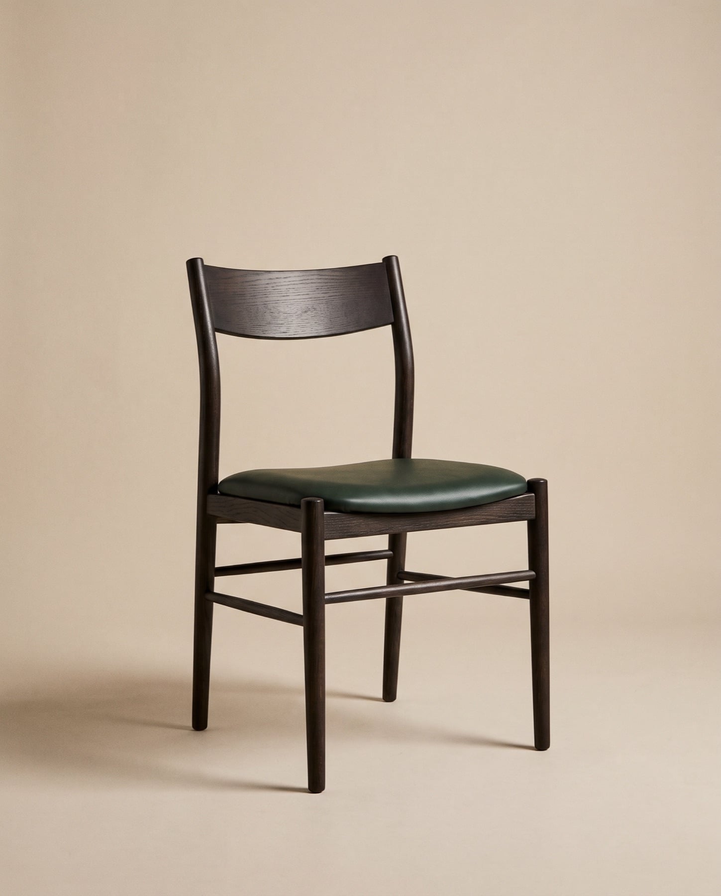 Nord dining chair with a near-black stained ash frame and a forest-green leather seat