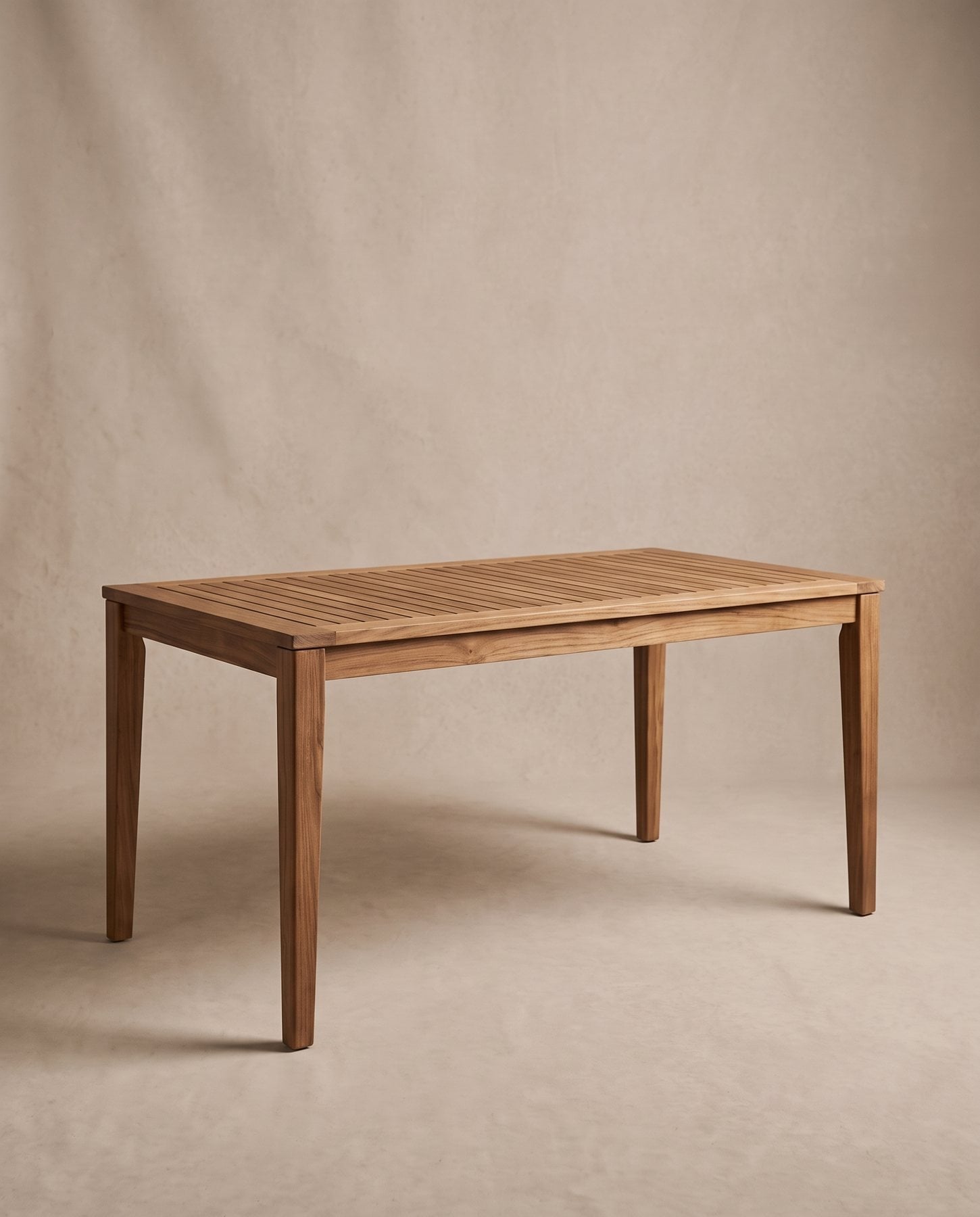 Marea outdoor dining table in solid teak with a slatted top and tapered square legs