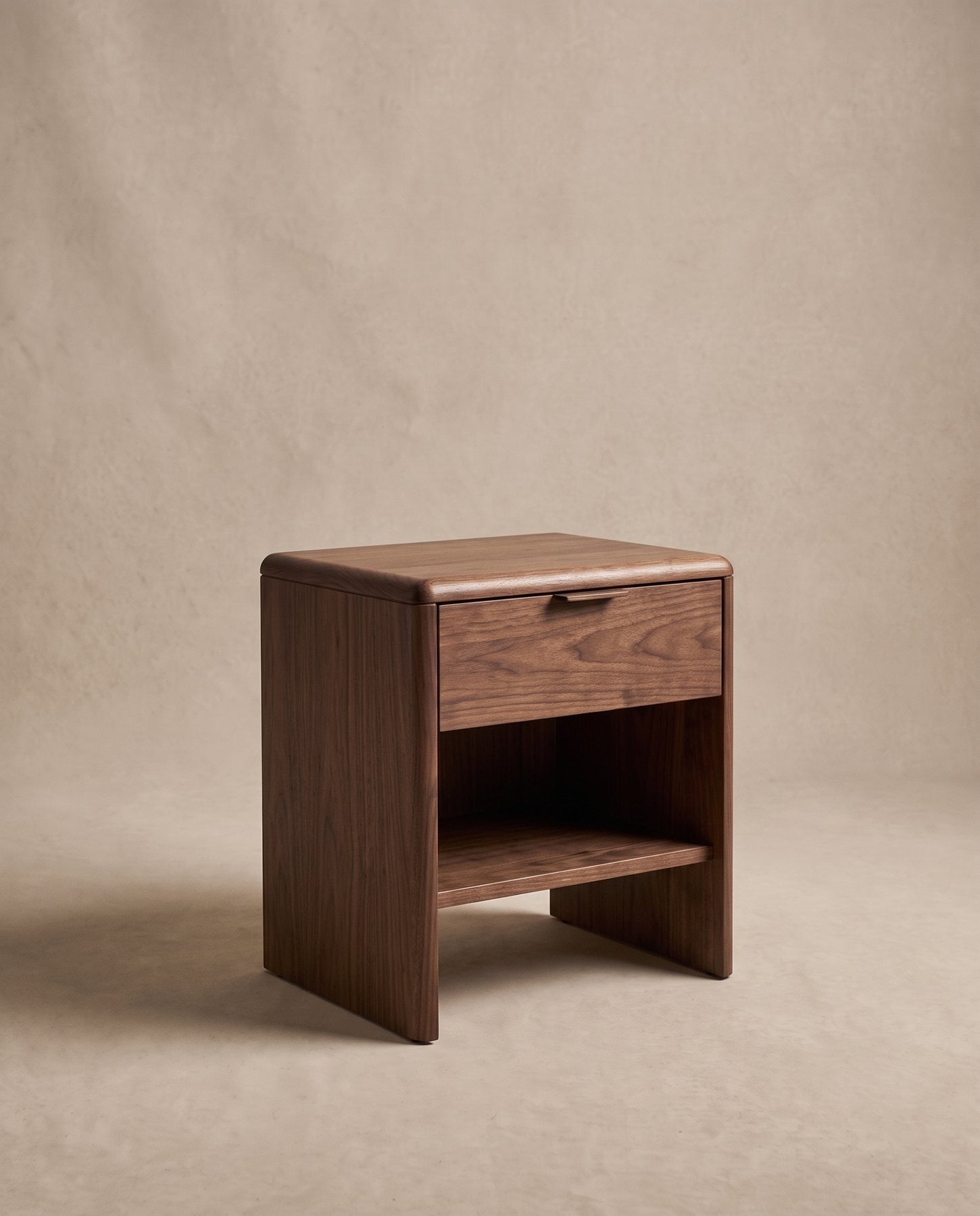 Nox bedside table in black walnut with one drawer, an open shelf and a rounded top edge