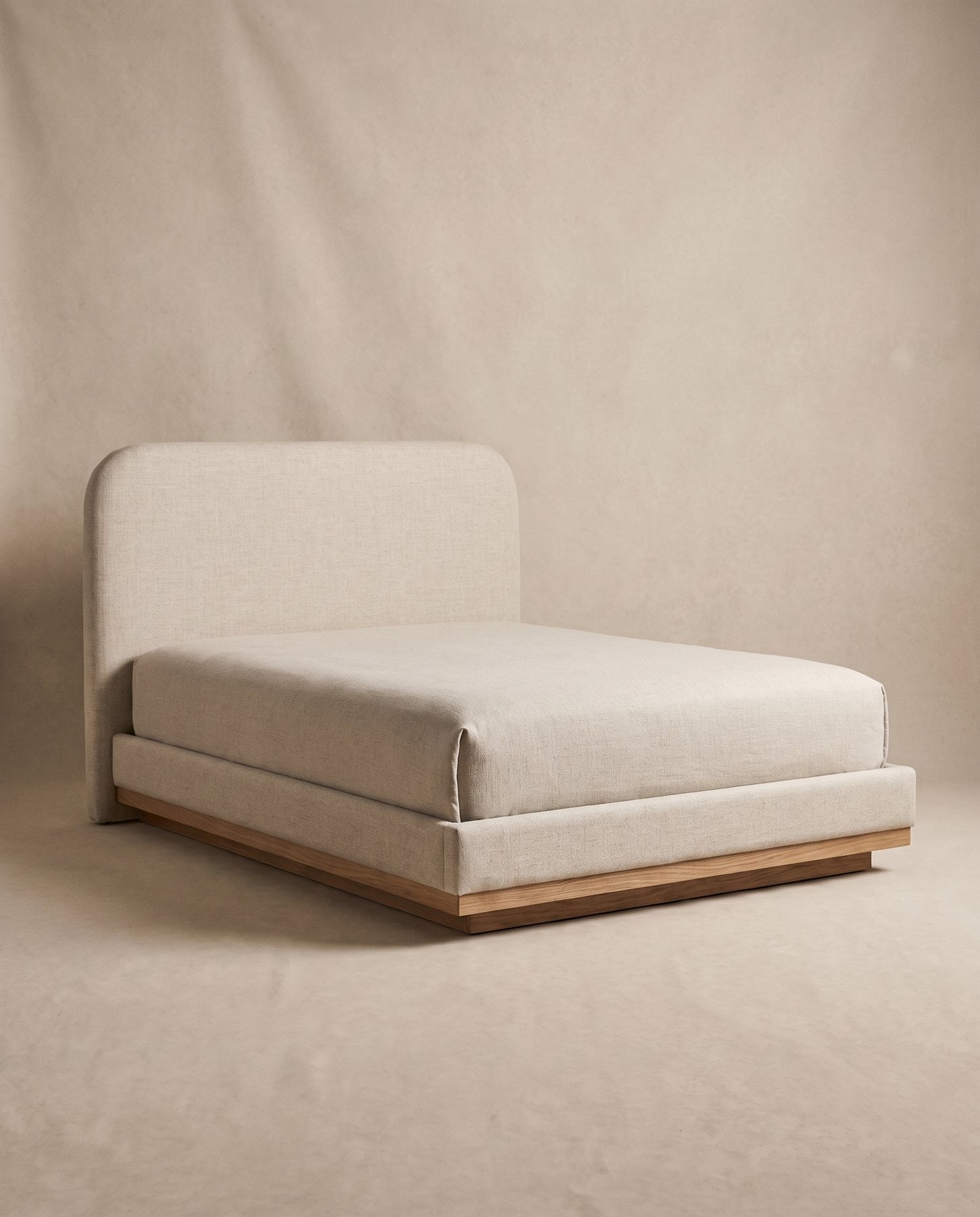 Hale bed upholstered in oatmeal linen with a tall rounded headboard on a slim oak plinth