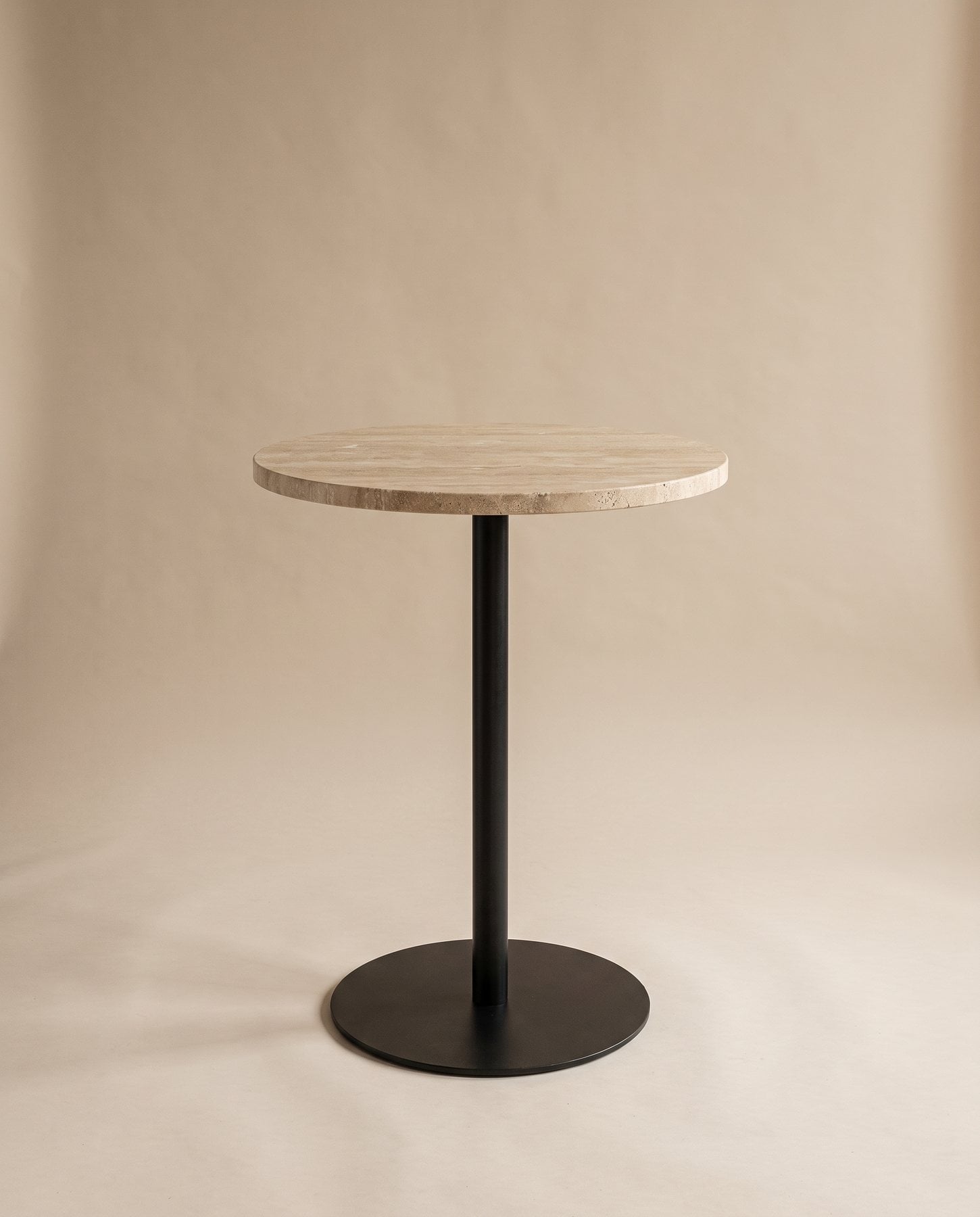 Perch bar table with a round honed travertine top on a blackened steel column and disc base